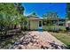 Landscaped backyard with mature trees and a brick paver patio, providing a private oasis at 420 Roanoke St, Dunedin, FL 34698