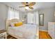 Cozy bedroom featuring a ceiling fan, hardwood floors, and a sunny window at 420 Roanoke St, Dunedin, FL 34698