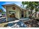 Quaint home featuring a covered carport with lattice, a decorative sun accent, and a well-kept front yard at 420 Roanoke St, Dunedin, FL 34698