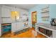 Well-lit kitchen featuring white cabinetry, hardwood floors, and modern appliances with outdoor access at 420 Roanoke St, Dunedin, FL 34698