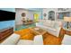 Bright living room featuring hardwood floors, a comfortable sofa, and an open layout into the dining area at 420 Roanoke St, Dunedin, FL 34698