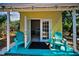 Cozy covered patio with inviting blue chairs, perfect for relaxing and enjoying the lush surroundings at 420 Roanoke St, Dunedin, FL 34698