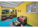 Vibrant sunroom with seating, outdoor views, and cheerful yellow decor at 420 Roanoke St, Dunedin, FL 34698