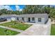 Aerial view of freshly painted single-story home with driveway and manicured landscaping at 4812 El Capistrano Dr, Tampa, FL 33634