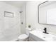 Modern bathroom features a white tiled shower, a gray vanity, and a black faucet at 4812 El Capistrano Dr, Tampa, FL 33634