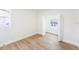Bright bedroom with wood floors, window view, and doorway to another room at 4812 El Capistrano Dr, Tampa, FL 33634