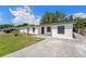 Front view of freshly painted single-story home with driveway and manicured landscaping at 4812 El Capistrano Dr, Tampa, FL 33634