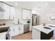 Bright kitchen features stainless steel appliances, white cabinetry and an island with quartz countertop at 4812 El Capistrano Dr, Tampa, FL 33634