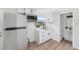 Modern kitchenette with stainless steel appliances, white cabinets, and adjacent bathroom at 4812 El Capistrano Dr, Tampa, FL 33634