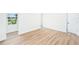 Bright open room with wood floors, new white paint, large window and doorway at 4812 El Capistrano Dr, Tampa, FL 33634