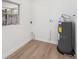 Utility room with water heater, new floors, and window for natural light at 4812 El Capistrano Dr, Tampa, FL 33634