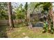 Fenced backyard and pool area with beautiful tropical foliage, creating a private oasis at 5619 Essex Ct, Palm Harbor, FL 34685