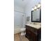 Bathroom featuring wood-look floors, a dark vanity, and a shower/tub combo with white tile surround at 5619 Essex Ct, Palm Harbor, FL 34685