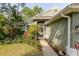 Charming home exterior with lush landscaping, including tropical plants near the front door at 5619 Essex Ct, Palm Harbor, FL 34685