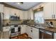 Gourmet kitchen with stainless steel appliances and beautiful tile backsplash at 5619 Essex Ct, Palm Harbor, FL 34685