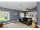 Inviting living room with a leather sofa, a ceiling fan, and multiple windows with backyard views at 5619 Essex Ct, Palm Harbor, FL 34685