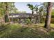 A large, screened-in pool abuts lush landscaping and trees at 5619 Essex Ct, Palm Harbor, FL 34685