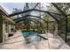 Beautiful screened-in pool with spacious surrounding brick-paved deck and lounge chairs at 5619 Essex Ct, Palm Harbor, FL 34685