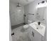 Updated bathroom featuring tiled shower with black fixtures and white marble floors and vanity at 5817 Liverpool Dr, Tampa, FL 33615