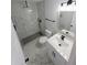 Updated bathroom with tiled shower, modern fixtures, and white marble floors and vanity at 5817 Liverpool Dr, Tampa, FL 33615