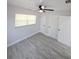 Bright bedroom with a ceiling fan, window, gray vinyl flooring, and ample closet space at 5817 Liverpool Dr, Tampa, FL 33615