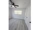 Bright bedroom with a ceiling fan, window, gray vinyl flooring, and ample closet space at 5817 Liverpool Dr, Tampa, FL 33615