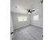 Bright bedroom with fresh paint, updated floors, ceiling fan and natural light from two windows at 5817 Liverpool Dr, Tampa, FL 33615