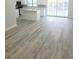 Open floor plan with gray vinyl flooring, kitchen island, and a view of the pool through sliding doors at 5817 Liverpool Dr, Tampa, FL 33615