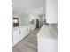 Renovated kitchen with white cabinets, quartz countertops, new floors, and stainless-steel appliances at 5817 Liverpool Dr, Tampa, FL 33615