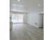 Open floor plan with gray vinyl flooring, recessed lighting, and sliding door access to the backyard pool at 5817 Liverpool Dr, Tampa, FL 33615