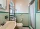 This bathroom features classic green and white tilework, a pedestal sink, and an updated toilet at 6350 18Th N Ave, St Petersburg, FL 33710