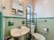 This bathroom features classic green and white tilework, a pedestal sink, and an updated toilet at 6350 18Th N Ave, St Petersburg, FL 33710