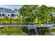 Backyard view with lush greenery, a dock, and a glimpse of a waterway at 6532 Simone Shores Cir, Apollo Beach, FL 33572