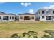 Backyard view of a modern home featuring a manicured lawn, minimalist landscaping, and sleek architectural design at 6532 Simone Shores Cir, Apollo Beach, FL 33572