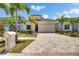 Beautifully landscaped single-story home with a paved driveway and palm trees at 6532 Simone Shores Cir, Apollo Beach, FL 33572