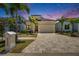 Stunning home exterior at twilight featuring manicured landscaping, a paved driveway, and modern architectural design at 6532 Simone Shores Cir, Apollo Beach, FL 33572