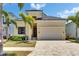 Inviting single-Gathering home features a manicured lawn, tropical landscaping, and a spacious two-car garage at 6532 Simone Shores Cir, Apollo Beach, FL 33572