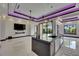 Contemporary kitchen featuring a large island, sleek countertops, and violet LED accent lighting at 6532 Simone Shores Cir, Apollo Beach, FL 33572