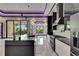 Modern kitchen with sleek black and white cabinetry, quartz countertops, stainless steel appliances, and marble flooring at 6532 Simone Shores Cir, Apollo Beach, FL 33572
