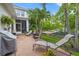 Relaxing brick patio with lounge chairs, outdoor grill, and lush landscaping with palm trees at 702 34Th N Ave, St Petersburg, FL 33704