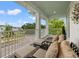 Inviting covered balcony with seating area, stylish cushions, and views of the neighborhood street at 702 34Th N Ave, St Petersburg, FL 33704