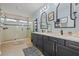 Modern bathroom with double sink vanity, framed mirrors, and glass enclosed shower at 702 34Th N Ave, St Petersburg, FL 33704
