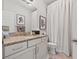 Well-maintained bathroom featuring a granite countertop vanity, framed mirror, and shower with curtain at 702 34Th N Ave, St Petersburg, FL 33704