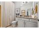 Well-lit bathroom with granite countertop, white cabinets, a framed mirror, and shower with curtain at 702 34Th N Ave, St Petersburg, FL 33704