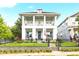 Charming two-story home with a welcoming porch, a well-manicured lawn, and decorative landscaping at 702 34Th N Ave, St Petersburg, FL 33704
