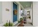 Charming covered porch with a blue front door accented with flowers, plants, and stylish outdoor furniture at 702 34Th N Ave, St Petersburg, FL 33704