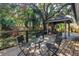 Outdoor living space featuring a spacious wooden deck with gazebo, seating and lush foliage at 7461 Pescador Pl, Seminole, FL 33772