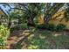 Serene backyard featuring lush landscaping, mature trees, and a cozy gazebo at 7461 Pescador Pl, Seminole, FL 33772