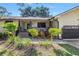 Inviting home exterior with a charming front porch, manicured landscaping, and neutral paint at 7461 Pescador Pl, Seminole, FL 33772