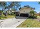 Charming home featuring a well-maintained lawn, mature trees, and an attached garage at 7461 Pescador Pl, Seminole, FL 33772
